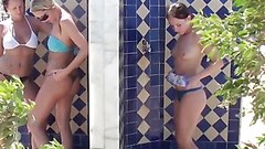 swimming video: Three girls in swim suits taking a shower at the beach