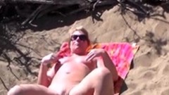 nudist video: Mature blonde caught masturbating on beach