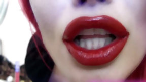lipstick video: Young woman with red hair puts red lipstick on and kisses the camera